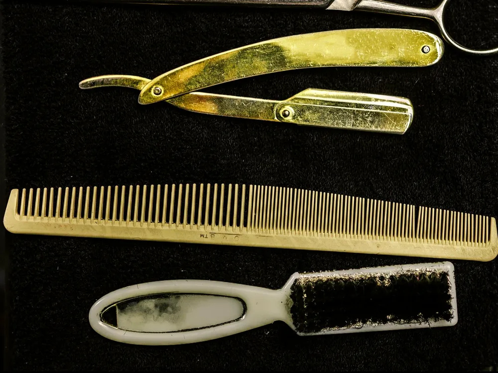 Rasoir en laiton, peigne et brosse à col posés sur la serviette du salon